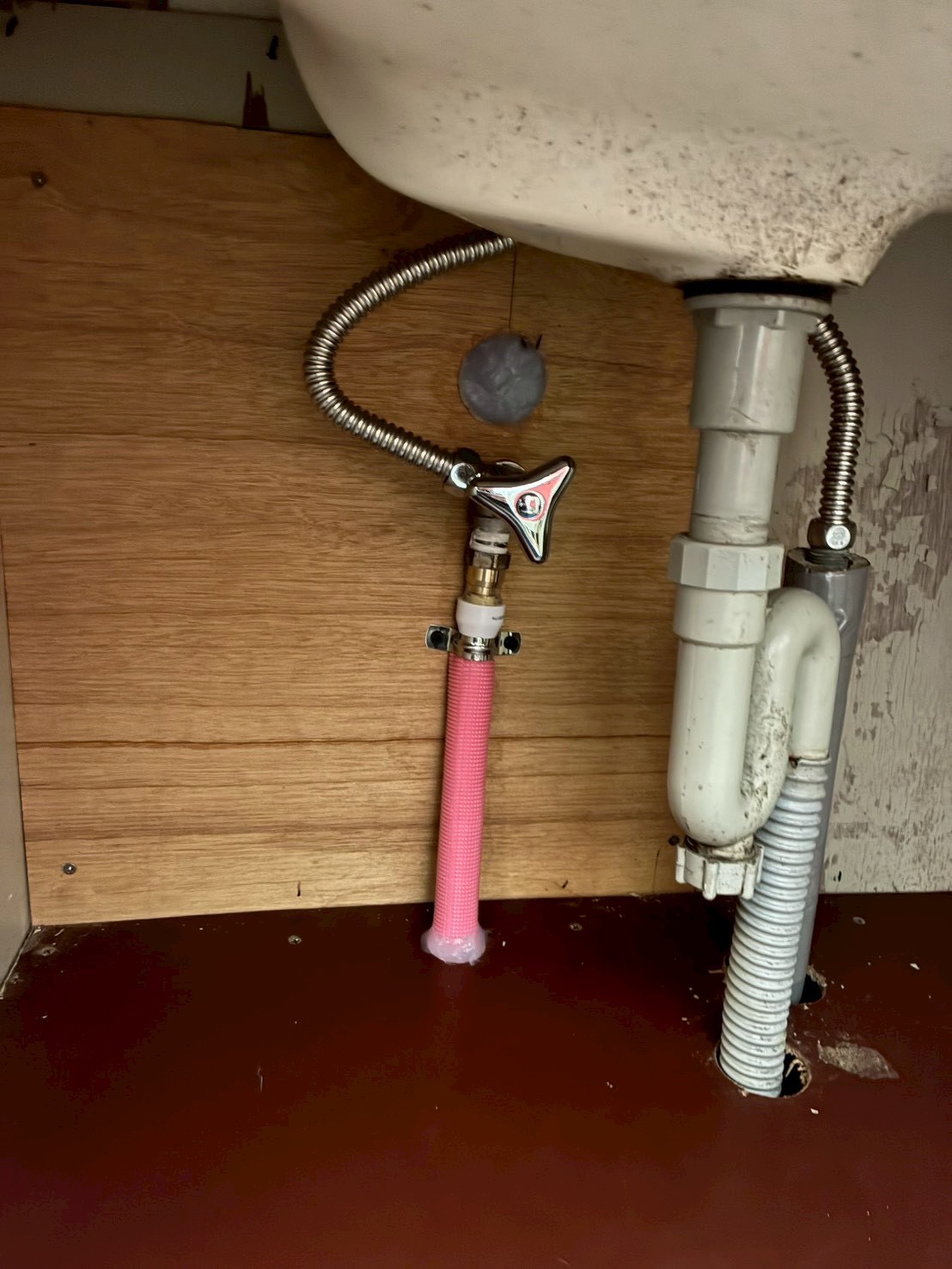 洗面台下に架橋ポリエチレン管(ピンク管)と新しい止水栓が取り付けられたアフター